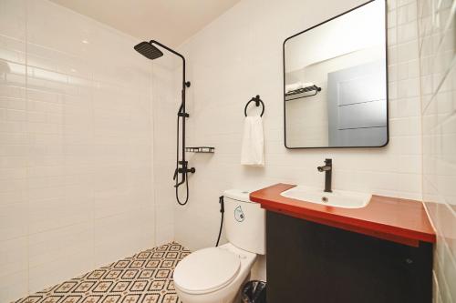 a bathroom with a toilet and a sink and a mirror at Hotel Gray in Boracay in Boracay