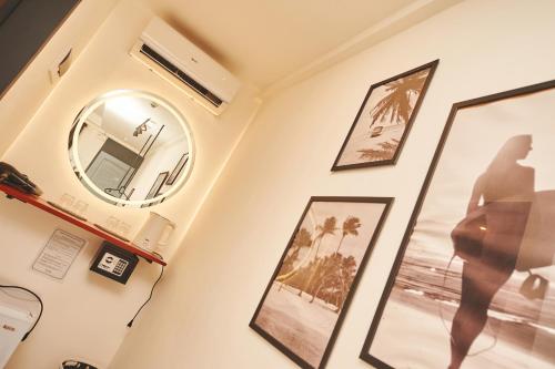 Hotel Gray in Boracay في بوراكاي: غرفة بها صور على الحائط ومرآة