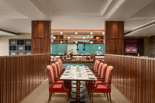 a dining room with a long table and chairs at Uday Palace Navsari, a member of Radisson Individuals in Navsāri