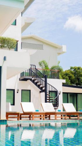 a villa with a swimming pool and a house at The Pago Design Hotel Phuket-SHA Plus in Phuket Town