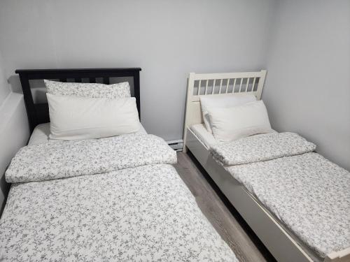 two beds sitting next to each other in a room at Blissfull Two Bedroom Suite Near surrey centre in Surrey