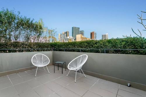 two chairs and a table on a balcony with a city at WILL1 - Stylish 2-Bed 2-Bath Oasis in Crows Nest Village in Sydney