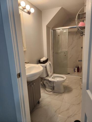 uma casa de banho com um WC, um lavatório e um chuveiro em New 2 bedroom suite near surrey centre em Surrey