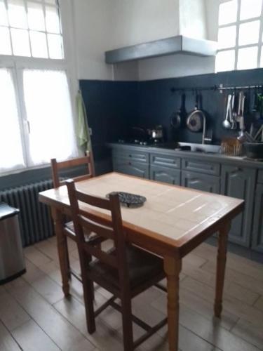 eine Küche mit einem Holztisch und einem Holzstuhl in der Unterkunft belle maison in Cormeilles-en-Parisis