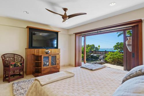 ein Wohnzimmer mit einem Flachbild-TV und einem Sofa in der Unterkunft Seahorse Luxury Suite at Seaspray Oceanview in Kailua-Kona