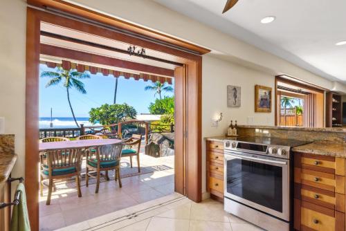a kitchen with a view of the ocean and a table with chairs at Seaspray Oceanview in Kailua-Kona