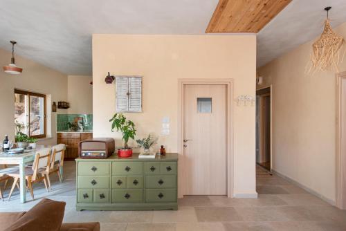 a living room with a green dresser and a table at בית האלה Home of Ela in Abirim