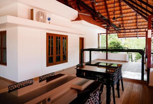 a living room with a piano and a table at Kalloos Island Backwater Resort in Kollam