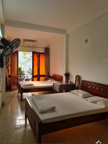 um quarto com três camas num quarto com uma janela em Nhà Nghỉ Hương Thúy - TTTM Royal City em Hanói