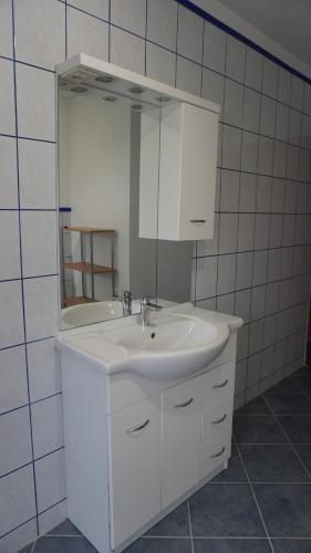 uma casa de banho com um lavatório branco e um espelho. em Geräumige Wohnung Nähe Autobahn A2 em Gleisdorf