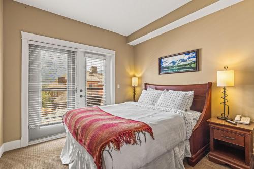 a bedroom with a bed and a window at Rockies Retreat by Canadian Rockies Vacation Rentals in Canmore