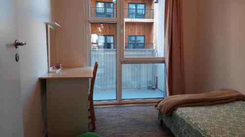 a bedroom with a desk and a large window at Stockholm Private Rooms in Shared Lovely, Amazing, Modern Apartment +Garden +BBQ in Stockholm
