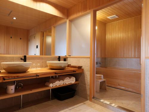 a bathroom with two sinks and a tub at NIPPONIA 田原本 マルト醤油 in Nara