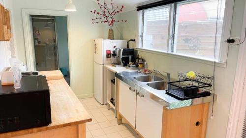 a kitchen with a sink and a refrigerator at Fanny Phillips Cottage in Beechworth