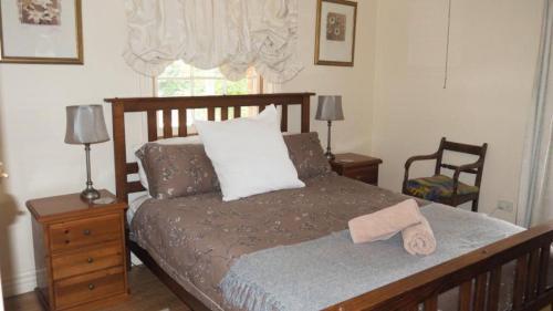 a bedroom with a bed and two chairs and a window at Hildas At Beechworth in Beechworth