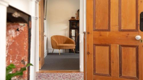 an open door with a chair in a hallway at Isabellas At Beechworth in Beechworth