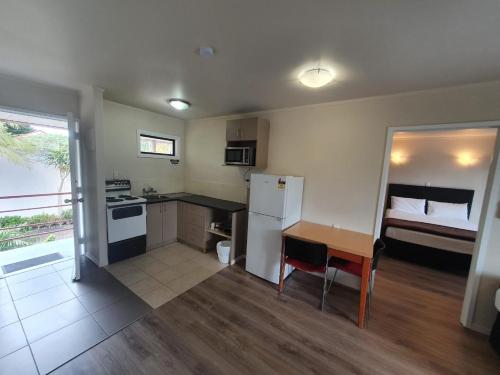 a small kitchen with a table and a bed at Ascot Epsom Motel in Auckland