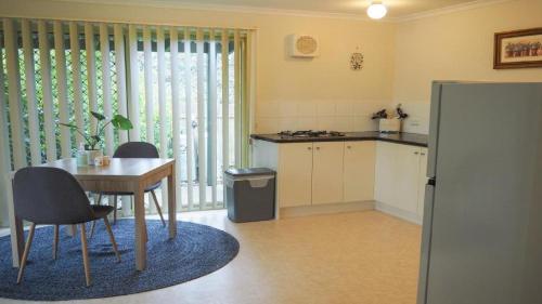 比奇沃斯Stanley Hideaway的厨房配有桌椅、桌子和冰箱。