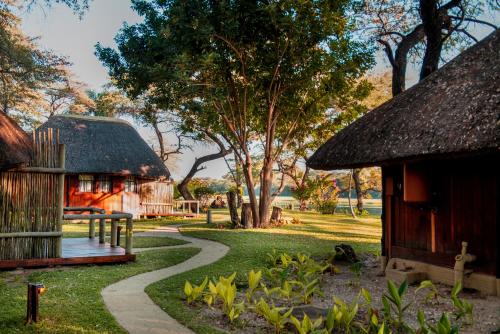 a garden with a path leading to a house at Gondwana Hakusembe River Lodge in Rundu