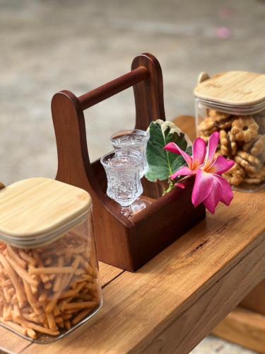 a wooden tray with a vase and a flower on it at S Lodge Pattaya formally Sabai Lodge in Pattaya