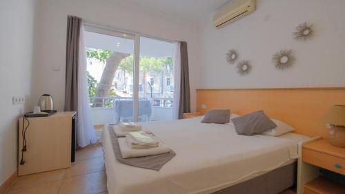 a bedroom with a bed and a large window at Mimosa Pension in Kaş