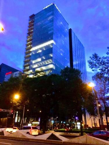 a tall glass building in a city at night at Moderno Departamento en Reforma 284 in Mexico City
