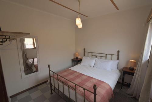 a bedroom with a bed and a mirror at Cottage on Diamond Street in Swakopmund