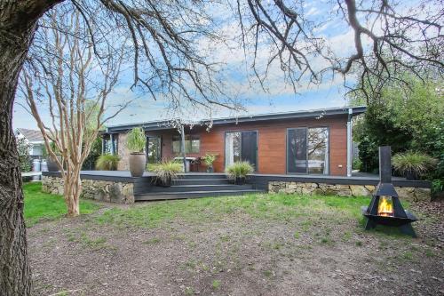 a home with a wooden house with a tree at Millie & Pips Beechworth Bungalow in Beechworth