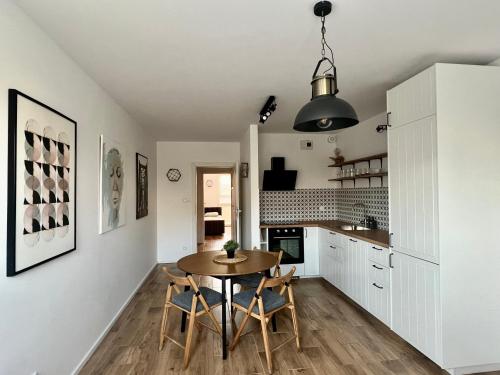 a kitchen and dining room with a table and chairs at Apartament Przytulny 3, self check in, parking in Rzeszów