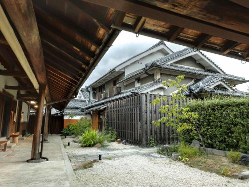 an external view of a house with a fence at NIPPONIA 田原本 マルト醤油 in Nara