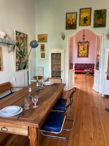 a dining room with a wooden table and blue chairs at Altbauwohnung in Gründerzeitvilla in Wuppertal
