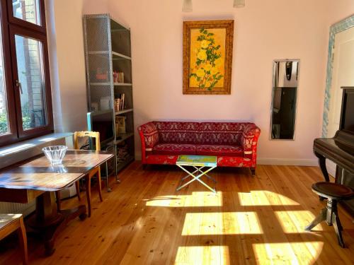 a living room with a red couch and a table at Altbauwohnung in Gründerzeitvilla in Wuppertal