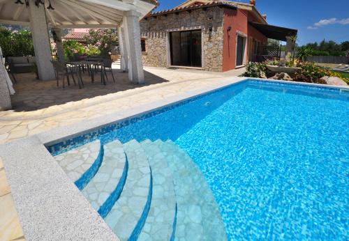 a swimming pool in a yard with a house at B&B I Graniti Sardi in Villasimius