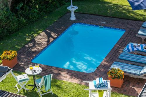 a swimming pool in a yard with a table and chairs at The Knysna Belle Guest House in Knysna