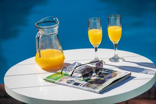 a table with two glasses and orange juice at The Knysna Belle Guest House in Knysna