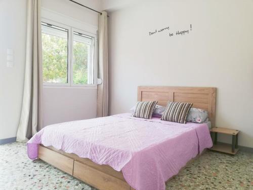 a bedroom with a large bed with a pink blanket at Family Inn in Athens