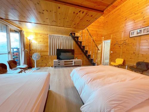 a bedroom with a bed and a tv in a room at Lala Mountain Homestay‧Cile Farm in Hualing