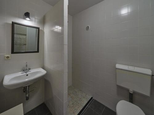 a white bathroom with a sink and a toilet at Traditional Apartment in Mesch with Terrace in Withuis