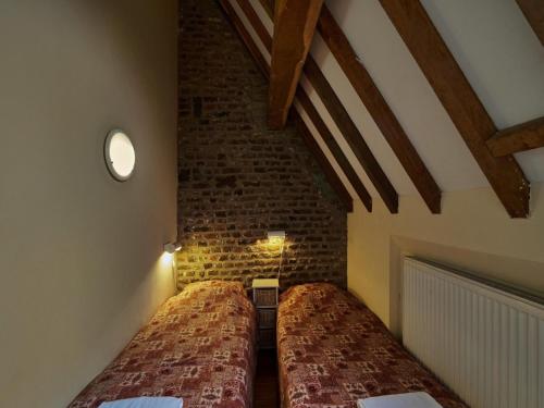 2 camas en una habitación con una pared de ladrillo en Spacious Villa near Town Center in Mesch, en Mesch