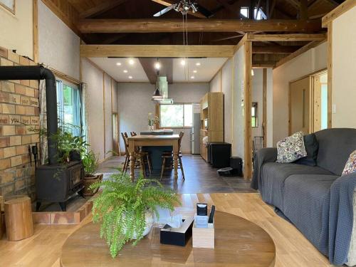 a living room with a couch and a table at 南阿蘇Villagehouseらかん in Minami Aso