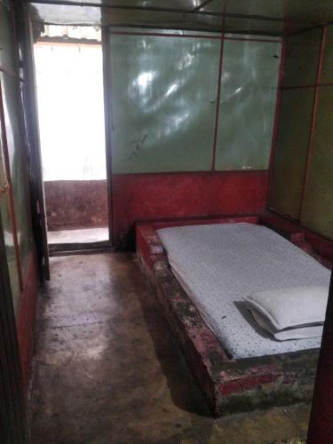 a small room with a bed and a window at Hotel O Barak Tambunan NearBelawan Port in Medan