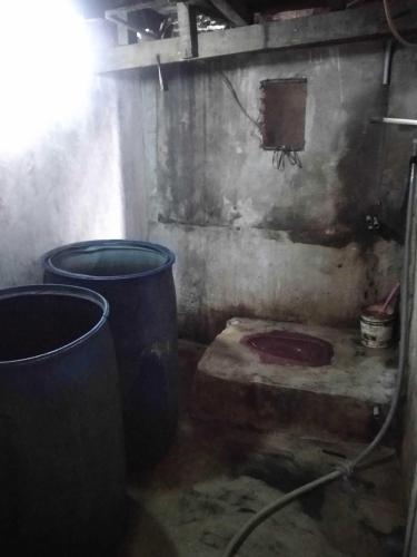 a dirty room with two large buckets in it at Hotel O Barak Tambunan NearBelawan Port in Medan