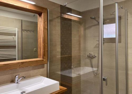 a bathroom with a sink and a glass shower at Apartmány Stará Voda in Stará Voda