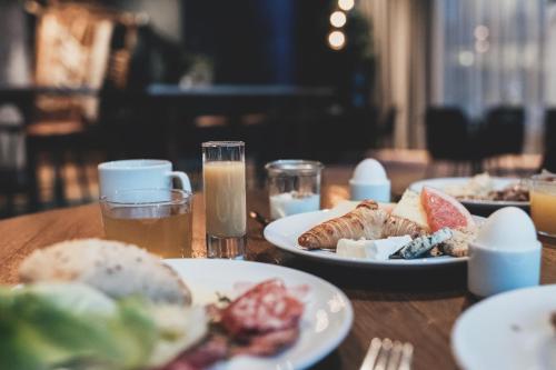 a wooden table topped with plates of food and drinks at Quality Hotel Tønsberg in Tønsberg