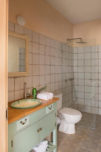 a bathroom with a sink and a toilet and a mirror at בית האלה Home of Ela in Abirim