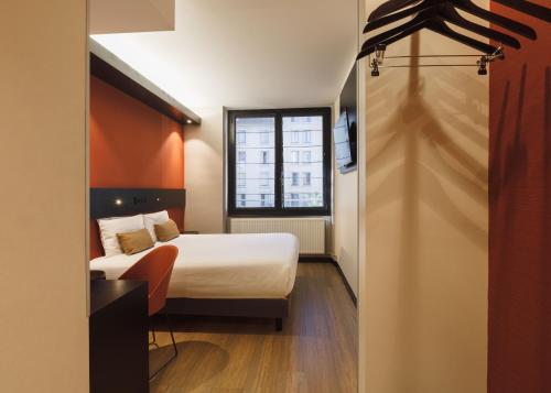 une chambre d'hôtel avec un lit et une fenêtre dans l'établissement Hôtel de Noailles, à Lyon