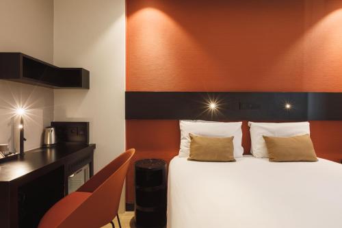 a hotel room with a bed and a desk at Hôtel de Noailles in Lyon