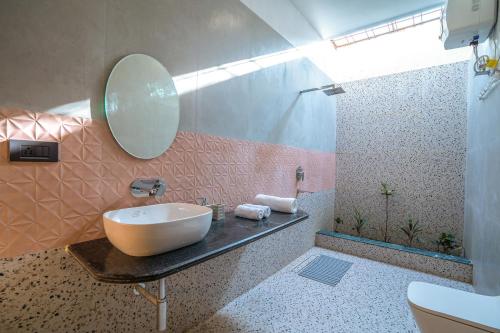 a bathroom with a sink and a mirror at StayVista at Sukoon with Bonfire in Lucknow