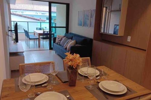 una mesa de comedor con platos y vasos. en Residencial Taormina - apartamento à beira-mar novinho! en Tamandaré