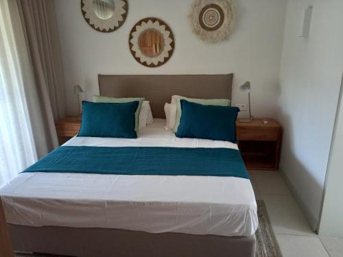 a bedroom with a large bed with blue pillows at Studio 2 The Waterclub in Rivière Noire
